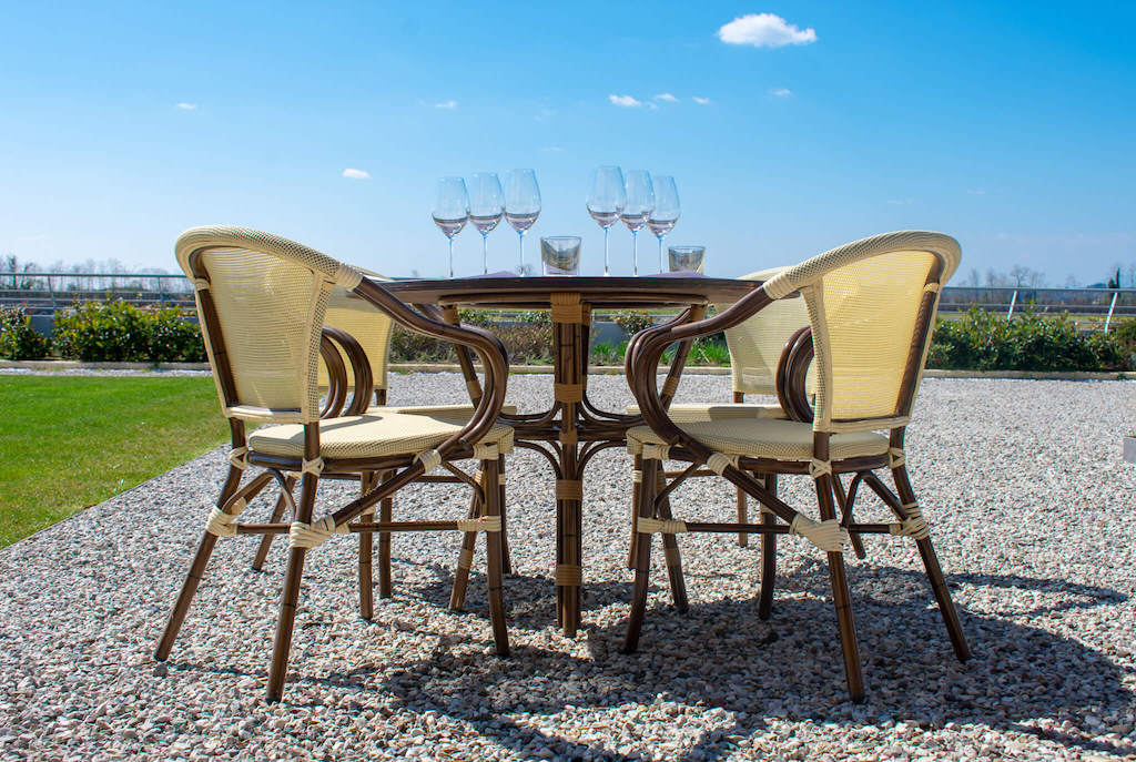 chairs and table in garden with wine glasses - Borgoluce winery