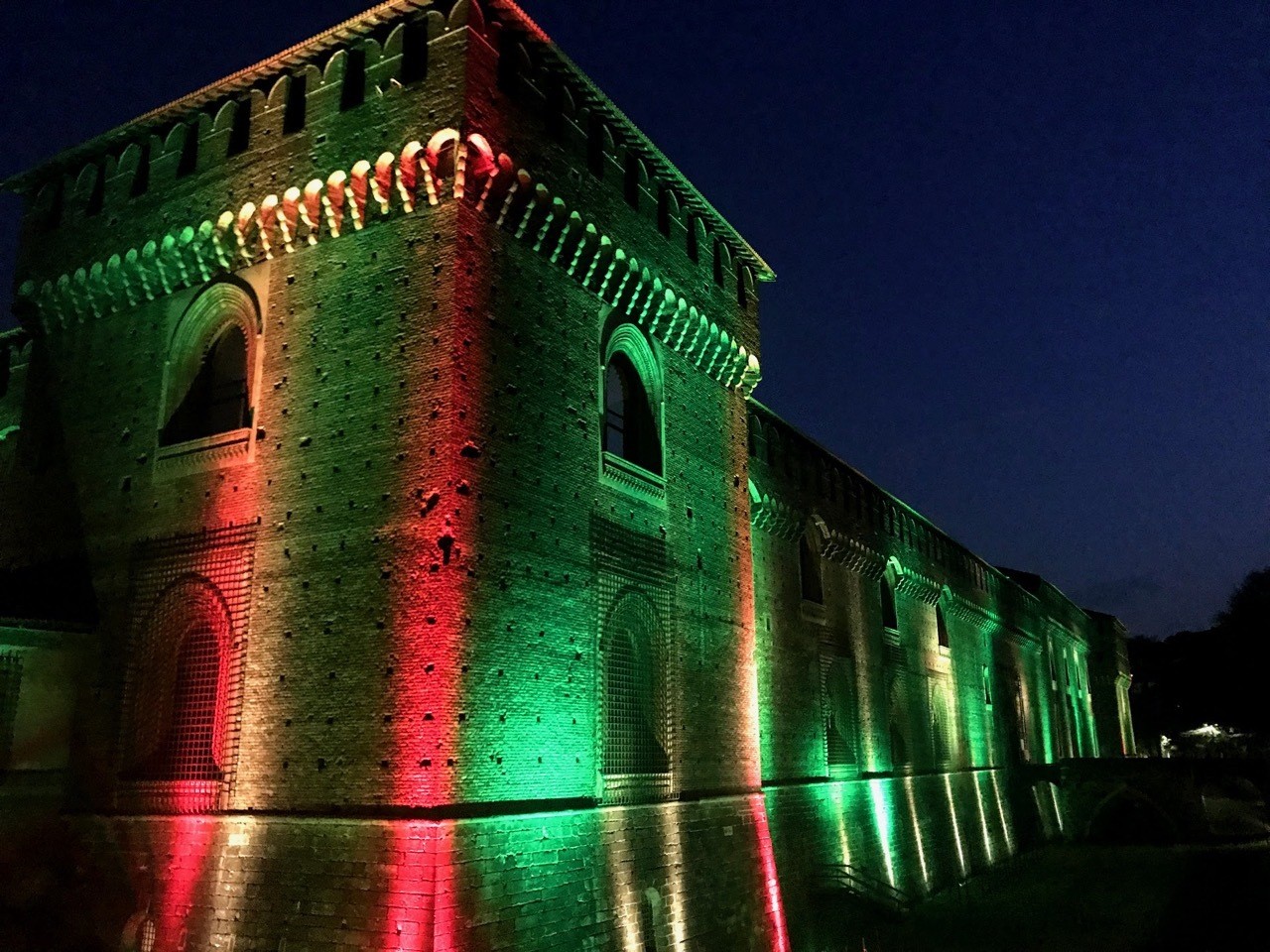 Sforza Castle illuminated red and green at night