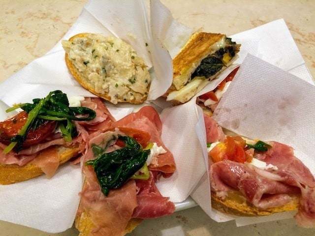 Plate of chicchetti with ham and cheese and greens