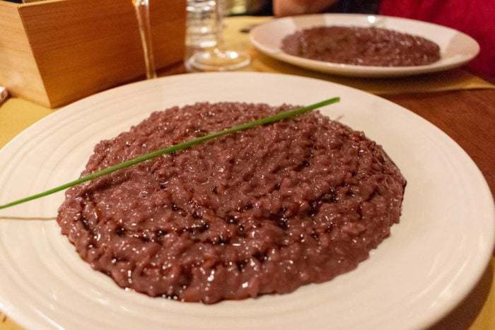 Plate of red risotto Risotto all’Amarone, specialty in Verona