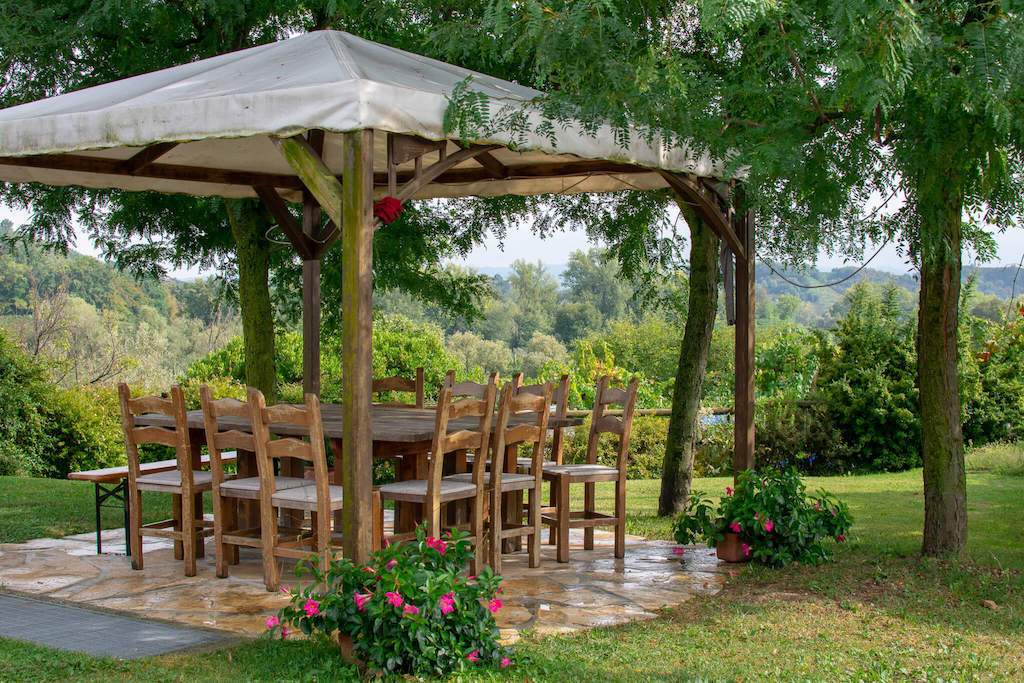 wooden table and chairs under umbrealla at Campion winery