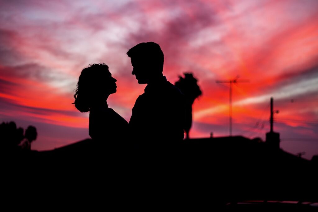 Couple in black shadow against red sunset