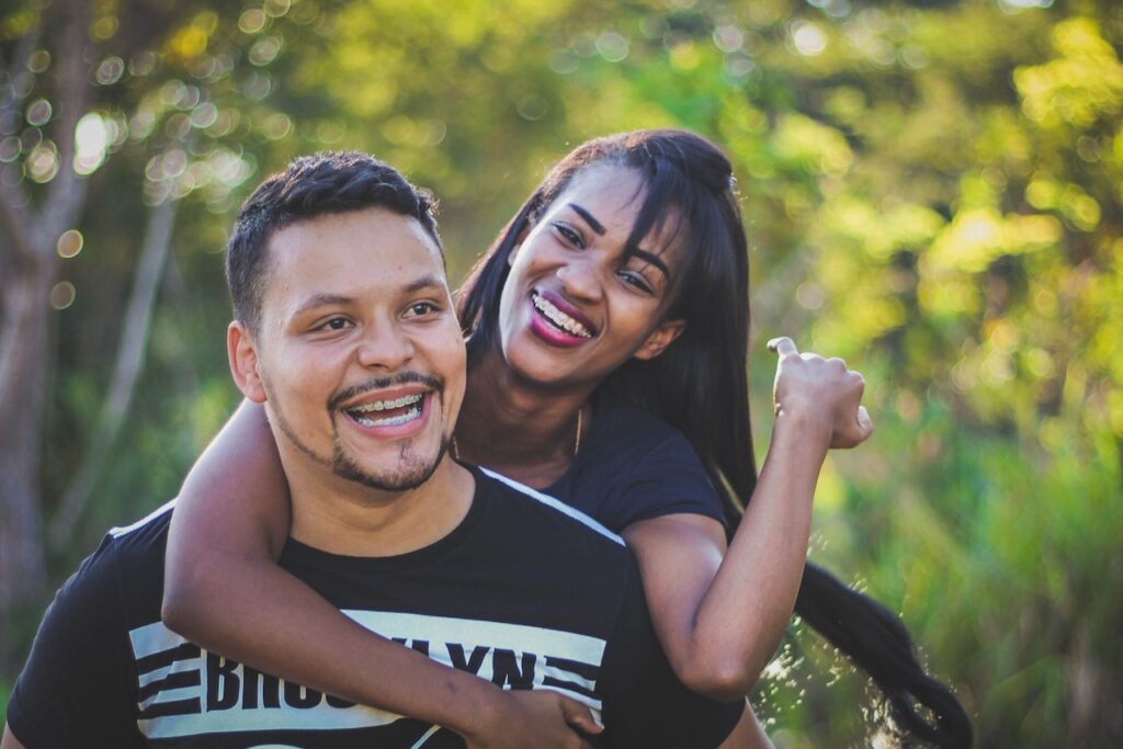 Woman hugging man against green leaf background