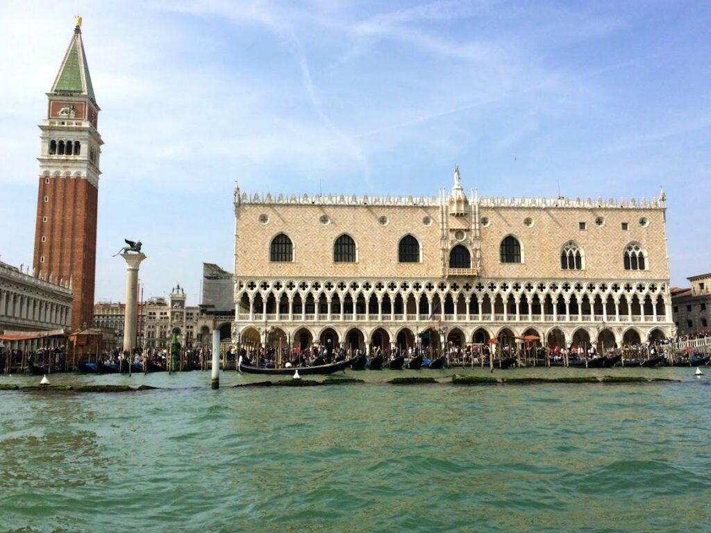 Doge Palace pink and white building seen from the waterfront with the Campanile next to it