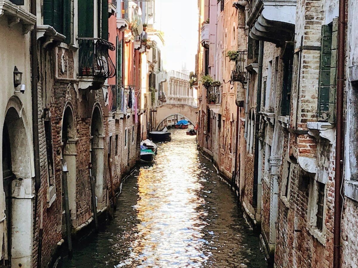 Narrow street with canal and bridge in backstreet Venice italy