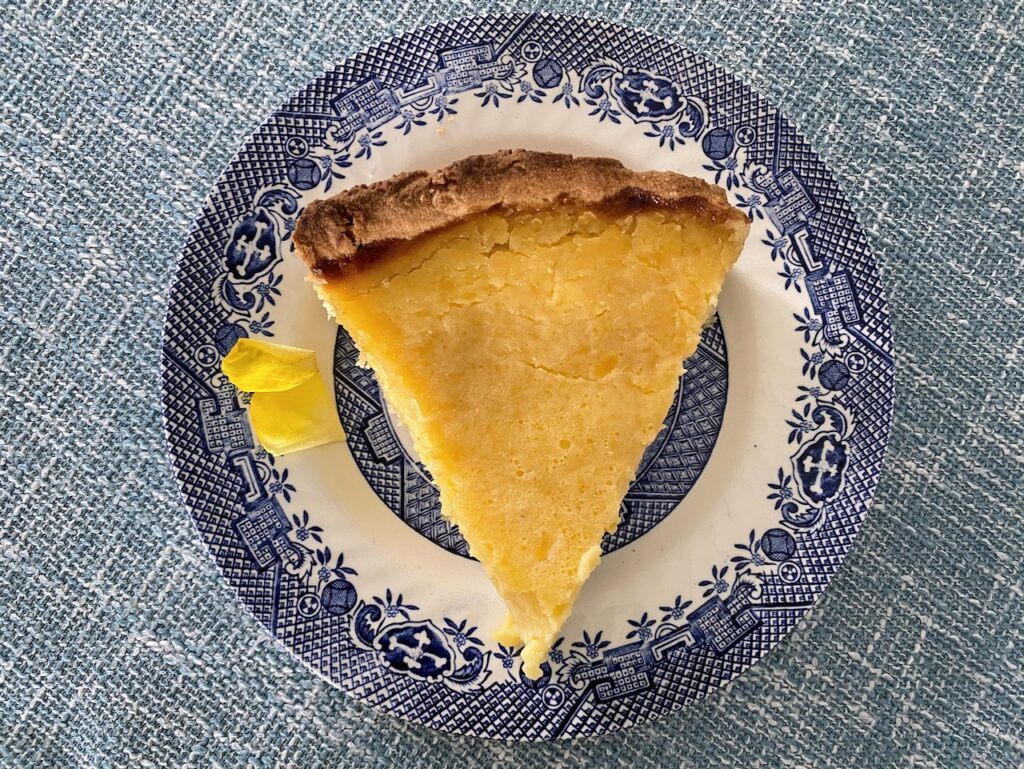 Custard tart - torta della nonna - on blue plate with rose petal decoration