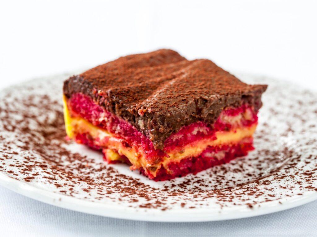 layers of bright red sponge and custard topped with chocolate